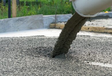 Concrete mixer pouring fresh concrete onto the site during concrete construction.