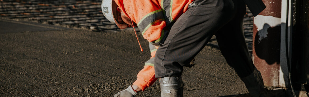 Construction worker leveling freshly poured concrete