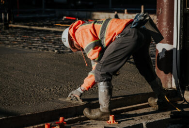 Construction worker leveling freshly poured concrete
