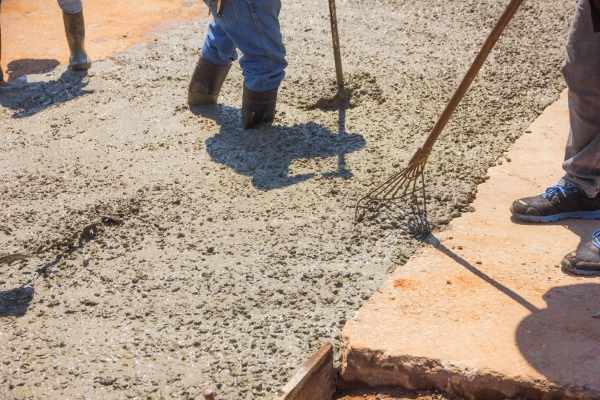 Workers leveling the newly poured concrete.