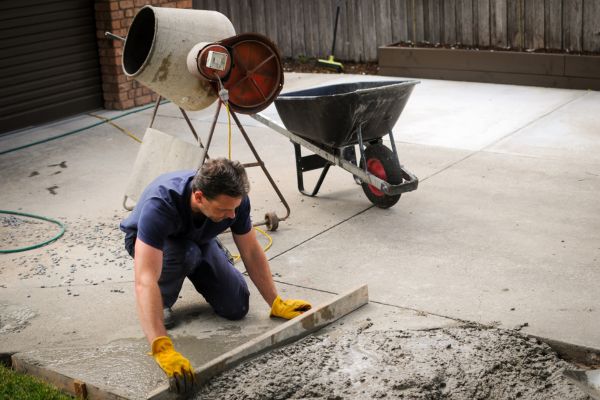 Worker performing ongoing residential driveway construction
