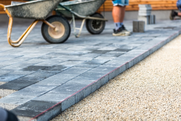 Workers laying concrete paving slabs.