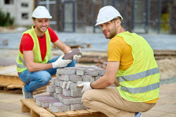 Workers moving bricks for building project
