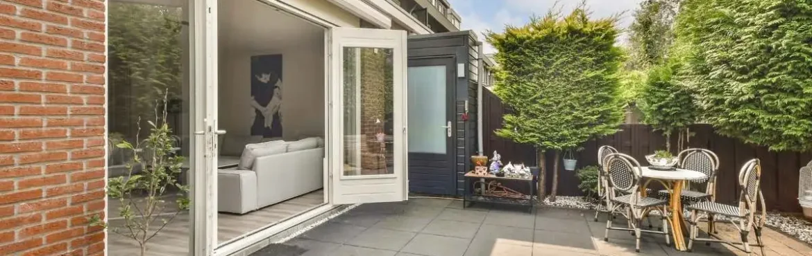 Concrete patio behind the house with outdoor seating.