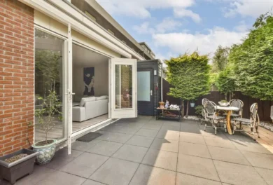 Concrete patio behind the house with outdoor seating.
