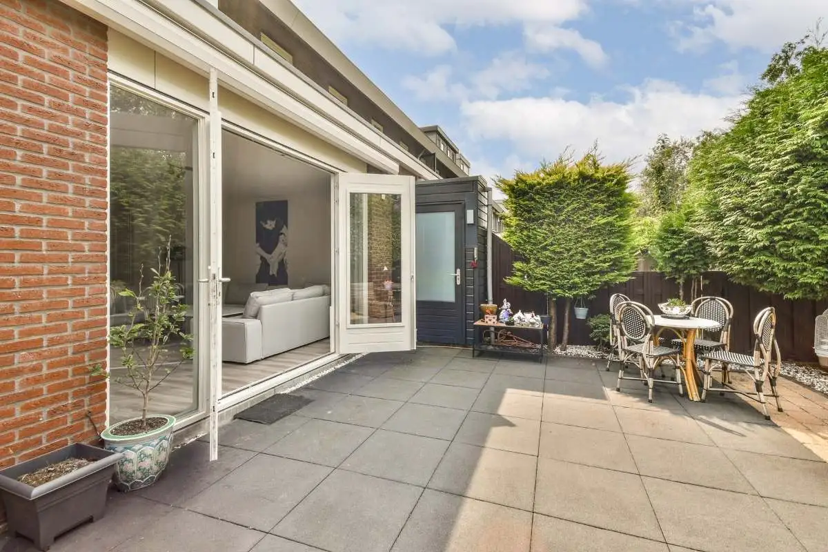 Concrete patio behind the house with outdoor seating.
